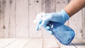 A person holding a cleaning solution bottle