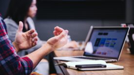 Someone talking with their hands in a boardroom meeting.