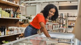 A woman looking into a grocery store cooler