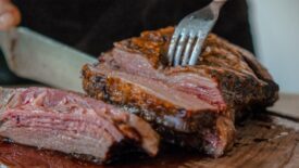 Image of someone cutting into a cooked slice of beef