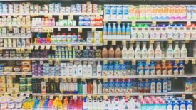 The dairy aisle of a grocery store with a refrigerator full of packaged food and beverages