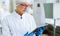 Female worker using tablet in food factory.